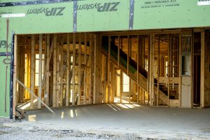 framing showing through the open garage doorway during a build at The Courtyards at Carr Farms